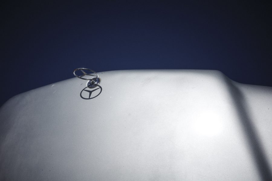 The iconic Mercedes-Benz three-pointed star stands out against the deep blue desert sky. In the refugee camps, this logo has evolved into a symbol of resilience. Models manufactured before the year 2000 are prized for their lack of complex electronics, allowing them to be repaired indefinitely with basic tools.